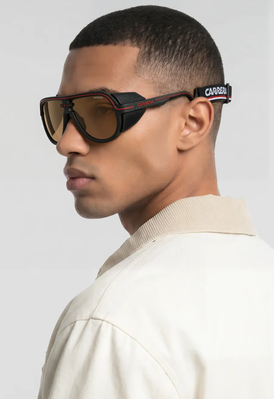 Close-up profile of a man wearing black Carrera shield sunglasses with amber lenses and an elastic strap: image generated for the Safilo commission.