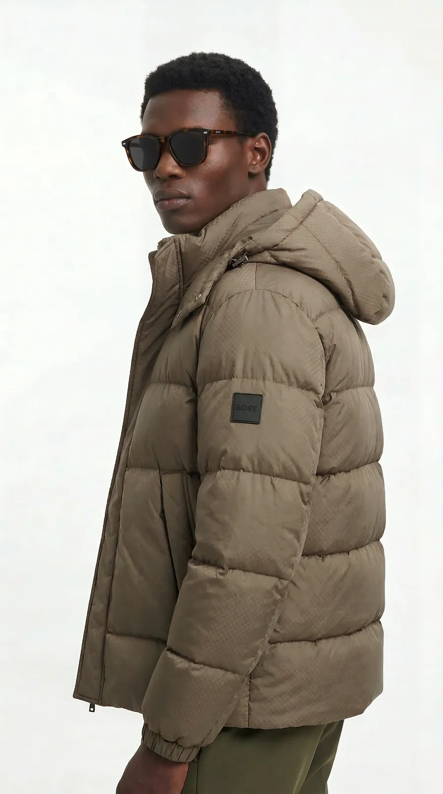 Man wearing dark sunglasses and a sand-coloured puffer jacket: image generated for the Safilo commission.